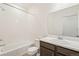 Bathroom with white tiled shower over tub, a toilet, and a vanity with a sink at 9313 Biscay St, Commerce City, CO 80022