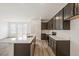 Kitchen features dark cabinets, stainless appliances, white counters, and an island with a sink and view of the backyard at 9313 Biscay St, Commerce City, CO 80022