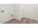 Laundry room features white walls, washer and dryer hookups, and wood-look flooring at 9313 Biscay St, Commerce City, CO 80022