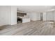 Expansive living room featuring hardwood floors, an open layout, a modern kitchen, and bright lighting at 9313 Biscay St, Commerce City, CO 80022