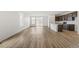 Spacious, light-filled living room featuring hardwood floors, white walls, and open access to the backyard at 9313 Biscay St, Commerce City, CO 80022