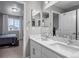 Bathroom with double sink vanity, framed mirrors and white cabinets, bedroom in background at 3945 John Ave, Castle Rock, CO 80104