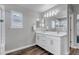 Bright bathroom featuring a double sink vanity with marble countertop, dark wood floors, and well-lit mirror at 3945 John Ave, Castle Rock, CO 80104
