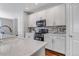 Modern kitchen features white cabinets, stainless steel appliances, and stylish backsplash at 3945 John Ave, Castle Rock, CO 80104