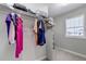 An organized walk-in closet with hanging clothes, shelves, and a window to let light in at 3945 John Ave, Castle Rock, CO 80104