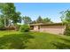Expansive backyard featuring lush green grass, mature trees, and a covered patio for outdoor enjoyment at 1235 S Benton St, Lakewood, CO 80232