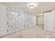 Unfinished basement featuring floral wallpaper and a door to additional space at 1235 S Benton St, Lakewood, CO 80232