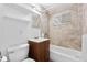 Tiled bathroom featuring a vanity, toilet, and bathtub with tiled walls and a shower at 1235 S Benton St, Lakewood, CO 80232