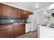 Well-appointed kitchen featuring dark wood cabinets, black counters, and white appliances at 1235 S Benton St, Lakewood, CO 80232