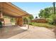 Back patio with open beams and a large cement area with a green lawn adjacent to it at 1235 S Benton St, Lakewood, CO 80232