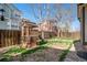 Fully-fenced backyard featuring a wooden playhouse, lawn, and trees at 19232 E Adriatic Pl, Aurora, CO 80013