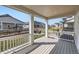 Covered back porch with white railing overlooking a charming yard and firepit area at 1308 E Hopkins Dr, Elizabeth, CO 80107