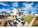 A charming backyard features a fire pit with Adirondack chairs, a well-manicured lawn, and a stylish fence at 1308 E Hopkins Dr, Elizabeth, CO 80107