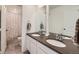 Bathroom featuring dual sinks, a dark countertop, a large mirror, and a shower with patterned curtain at 1308 E Hopkins Dr, Elizabeth, CO 80107