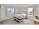Bright bedroom with two windows, a white metal bed frame, and plush carpet at 1308 E Hopkins Dr, Elizabeth, CO 80107