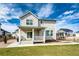 The backyard of a two-story home features a lush lawn, a porch, mature landscaping, and excellent natural light at 1308 E Hopkins Dr, Elizabeth, CO 80107
