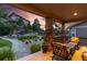 Covered back porch with comfortable outdoor seating, offering a view of the stone patio and landscaped backyard at 6728 S Catawba Way, Aurora, CO 80016