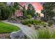Landscaped backyard showcasing a stone patio, fire pit, and seating area, surrounded by lush greenery under a colorful sky at 6728 S Catawba Way, Aurora, CO 80016