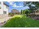 Manicured backyard features a well-maintained lawn, trees and shrubs, landscaping, and a wooden fence at 6728 S Catawba Way, Aurora, CO 80016
