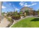 Landscaped backyard featuring a wooden fence, lush garden beds, and well-manicured lawn under a bright blue sky at 6728 S Catawba Way, Aurora, CO 80016