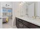 A double vanity bathroom featuring granite counters and mirrors overlooking a bright bedroom space at 6728 S Catawba Way, Aurora, CO 80016