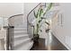 Elegant entryway with a curved staircase, wrought iron railing, and dark hardwood floors at 6728 S Catawba Way, Aurora, CO 80016