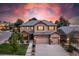 Stunning two-story home with a three-car garage and beautifully landscaped front yard at sunset at 6728 S Catawba Way, Aurora, CO 80016