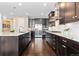 Spacious kitchen with dark wood cabinets, stainless steel appliances, and granite countertops at 6728 S Catawba Way, Aurora, CO 80016