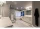 Bright bathroom with a modern walk-in shower, freestanding tub, and marble tile at 98 Glenmoor Ln, Cherry Hills Village, CO 80113