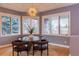 Cozy breakfast nook featuring large windows, a modern chandelier, and comfortable seating at 98 Glenmoor Ln, Cherry Hills Village, CO 80113