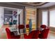 Elegant dining room with a glass table, red chairs, modern lighting, and an open view to the living area at 98 Glenmoor Ln, Cherry Hills Village, CO 80113