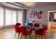 Stylish dining room with gray walls, modern art, and a glass table with unique red chairs at 98 Glenmoor Ln, Cherry Hills Village, CO 80113