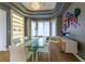 Bright dining room with a glass table, modern cabinetry, and built-in display shelving at 98 Glenmoor Ln, Cherry Hills Village, CO 80113