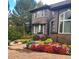 Gray home with colorful landscaping, brick walkway, and manicured shrubbery at 98 Glenmoor Ln, Cherry Hills Village, CO 80113