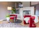 This contemporary sitting area features a fireplace, hardwood floors, stylish red velvet chairs and a sleek coffee table at 98 Glenmoor Ln, Cherry Hills Village, CO 80113