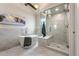 Modern bathroom featuring a freestanding tub, glass-enclosed shower, and marble tile at 7311 Brixham Cir, Castle Pines, CO 80108