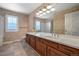 Bathroom with double vanity, ample lighting, and decorative wallpaper at 7311 Brixham Cir, Castle Pines, CO 80108