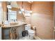 Unique powder room with a stone vessel sink, artistic lighting, decorative wall texture, and modern toilet at 7311 Brixham Cir, Castle Pines, CO 80108