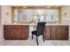 Bathroom featuring dual vanities, white countertops, dark cabinets, and a large mirror at 7311 Brixham Cir, Castle Pines, CO 80108