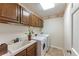 Clean laundry room featuring modern washer and dryer, cabinetry, sink, and tile flooring at 7311 Brixham Cir, Castle Pines, CO 80108