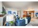 Open living room with a fireplace, leading to a kitchen with an island and seating at 7311 Brixham Cir, Castle Pines, CO 80108