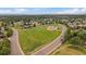 An aerial view showcases a green park area within a residential community on a bright, sunny day at 10859 W Fair Ave, Littleton, CO 80127