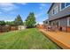 Backyard featuring a large lawn, storage shed, deck, and privacy fence at 10859 W Fair Ave, Littleton, CO 80127