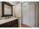 Well-lit bathroom with dark vanity and closet at 10859 W Fair Ave, Littleton, CO 80127