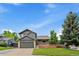 Inviting exterior view with lush lawn, brick details, two-car garage, and serene surroundings at 10859 W Fair Ave, Littleton, CO 80127