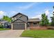 Charming two-story home featuring a well-maintained lawn, brick accents, and a spacious two-car garage in a quiet neighborhood at 10859 W Fair Ave, Littleton, CO 80127