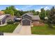 Aerial view showcasing a well-kept lawn, two-car garage, and a peaceful setting surrounded by mature trees at 10859 W Fair Ave, Littleton, CO 80127
