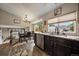 Kitchen and dining area with granite countertops, dark cabinets, stainless steel appliances, and eat in kitchen at 10859 W Fair Ave, Littleton, CO 80127