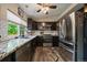 Well-appointed kitchen with black appliances, granite countertops, subway tile backsplash, and backyard views at 10859 W Fair Ave, Littleton, CO 80127