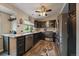 Modern kitchen with stainless steel appliances, dark cabinetry, granite countertops, and a ceiling fan at 10859 W Fair Ave, Littleton, CO 80127